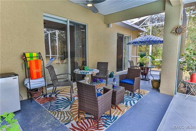 view of patio / terrace featuring ceiling fan and a lanai