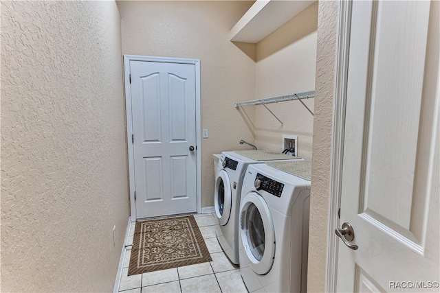 laundry room featuring washer and clothes dryer and light tile patterned floors