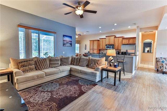 living room featuring ceiling fan and light hardwood / wood-style floors