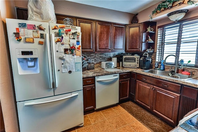 kitchen with dark brown cabinets, sink, stainless steel appliances, and tasteful backsplash