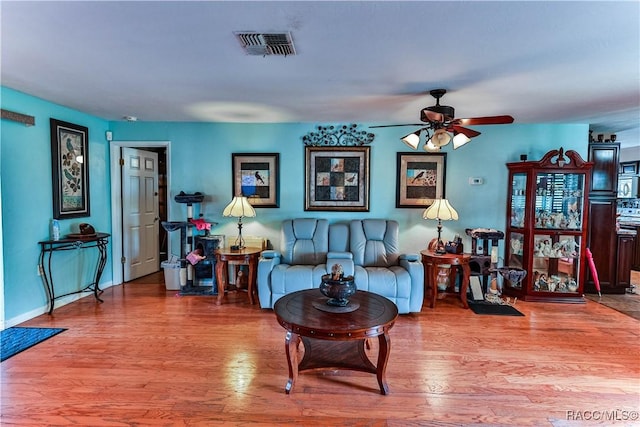 living room with ceiling fan and light hardwood / wood-style flooring