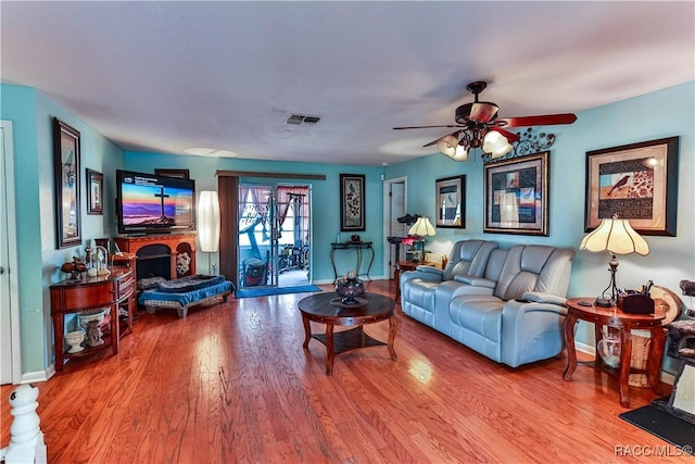 living room featuring hardwood / wood-style floors and ceiling fan