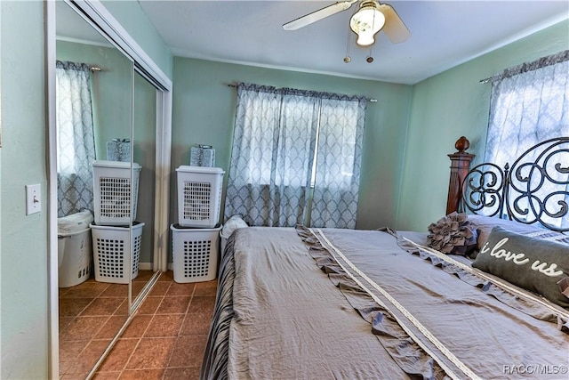 unfurnished bedroom with ceiling fan, a closet, and multiple windows