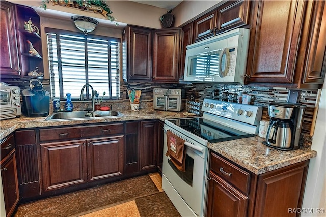 kitchen featuring backsplash, dark brown cabinetry, sink, and electric range oven