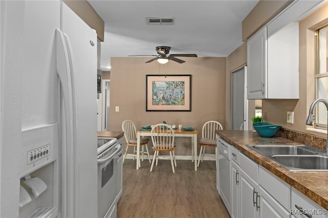 4 S Columbus St, Beverly Hills, FL 34465 - kitchen with white appliances, a ceiling fan, white cabinets, and dark countertops