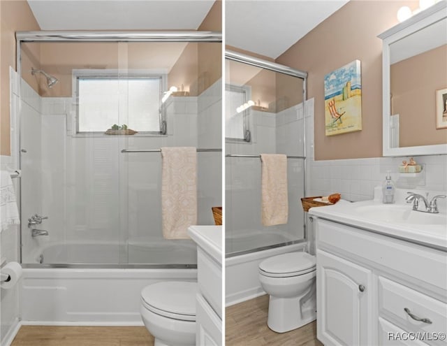4 S Columbus St, Beverly Hills, FL 34465 - bathroom featuring vanity, bath / shower combo with glass door, tile walls, wood finished floors, and wainscoting
