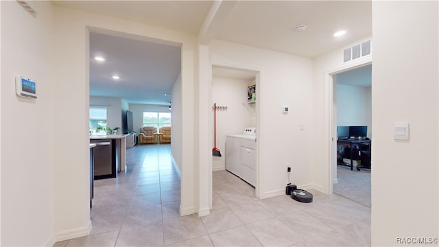 hall featuring washing machine and dryer and light tile patterned floors