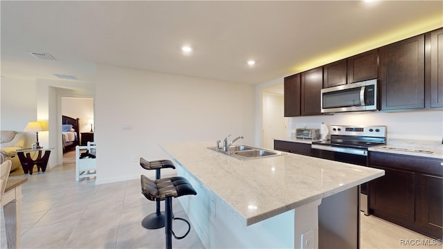 kitchen with a kitchen island with sink, sink, and stainless steel appliances