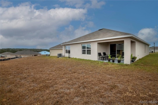 back of property featuring a yard, a patio, and central AC