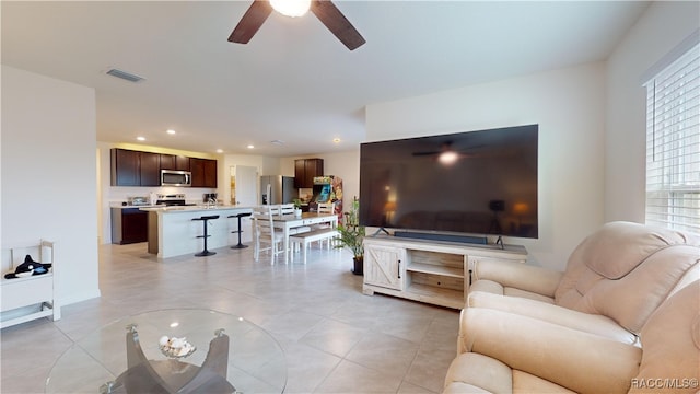 living room featuring ceiling fan, a healthy amount of sunlight, and light tile patterned flooring