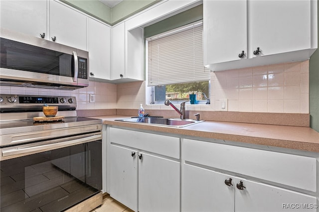 8 S Columbus St, Beverly Hills, FL 34465 - kitchen featuring appliances with stainless steel finishes, white cabinets, light countertops, and backsplash