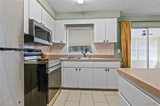 8 S Columbus St, Beverly Hills, FL 34465 - kitchen featuring stainless steel appliances, backsplash, white cabinetry, light tile patterned flooring, and a ceiling fan