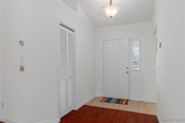 foyer featuring baseboards and wood finished floors