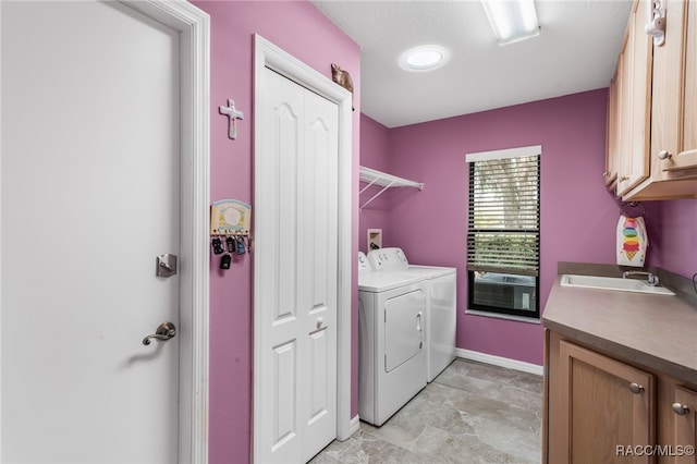 washroom featuring independent washer and dryer, sink, and cabinets