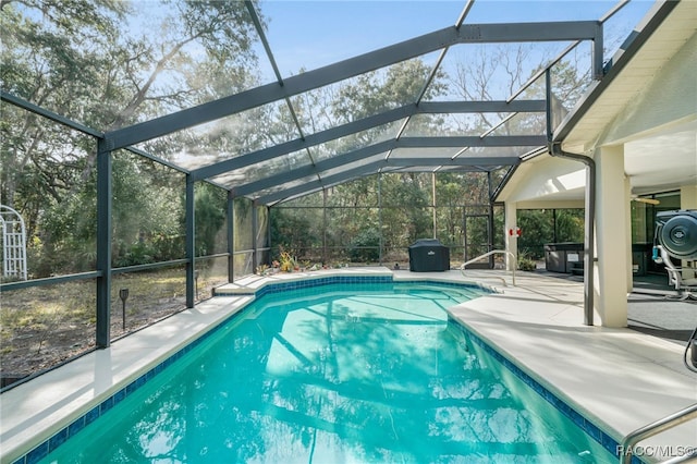 view of swimming pool featuring a lanai and a patio area