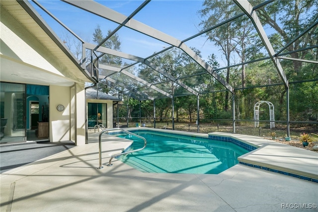 view of swimming pool featuring a patio and glass enclosure