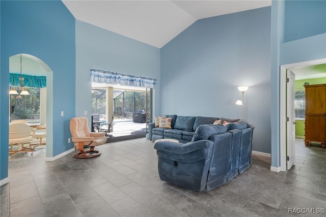 living room featuring tile patterned floors, high vaulted ceiling, and a notable chandelier