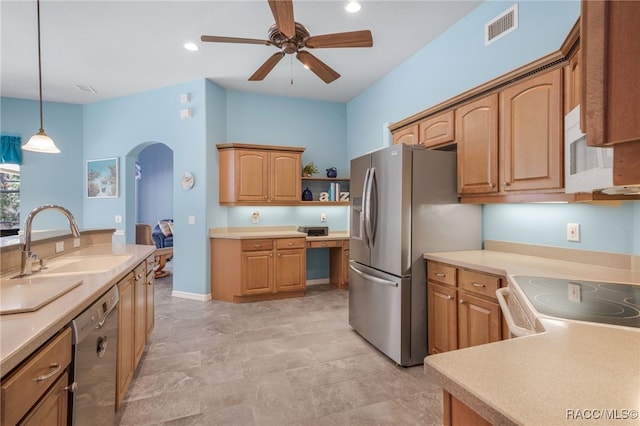 kitchen with sink, built in desk, pendant lighting, ceiling fan, and stainless steel appliances