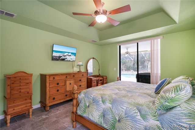 bedroom with access to exterior, ceiling fan, and a tray ceiling