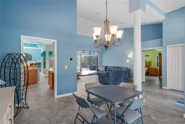 dining space featuring ornate columns, an inviting chandelier, and high vaulted ceiling