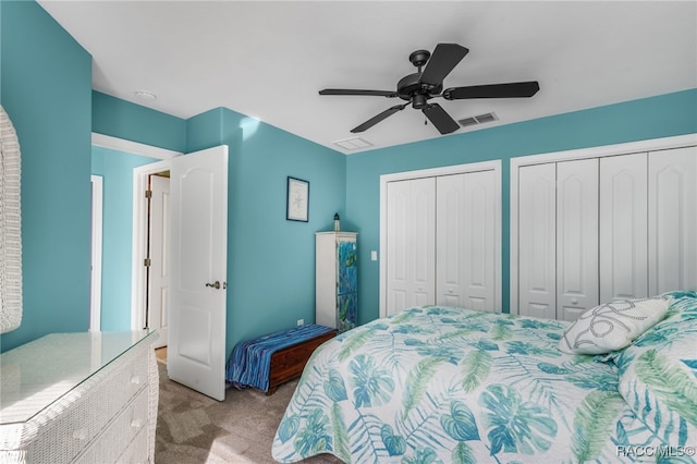 bedroom featuring light carpet, ceiling fan, and multiple closets