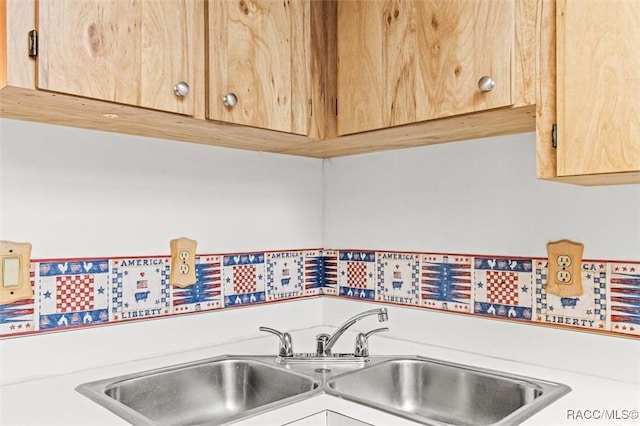 kitchen featuring light brown cabinets and a sink