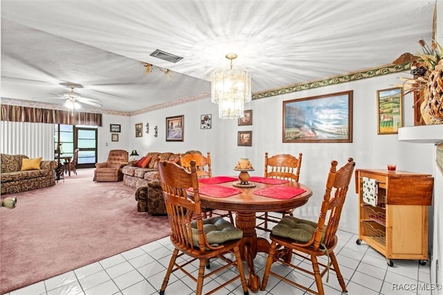 dining room featuring light tile patterned floors, ceiling fan with notable chandelier, visible vents, and light colored carpet