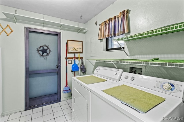 clothes washing area with light tile patterned flooring and washer and dryer