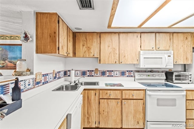 kitchen featuring a toaster, white appliances, a sink, visible vents, and light countertops