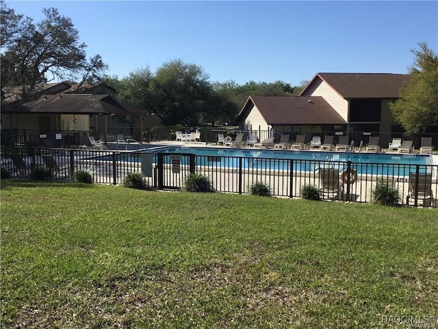 pool featuring a yard, a patio area, and fence