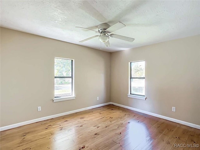 empty room featuring ceiling fan, a textured ceiling, and light wood-type flooring