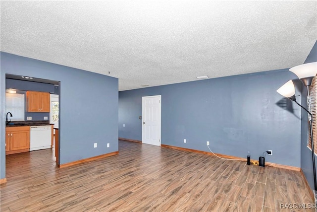 living room with sink, a textured ceiling, and hardwood / wood-style flooring