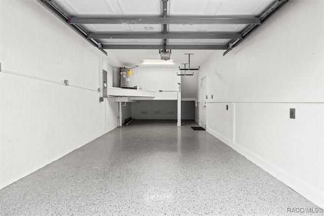 garage featuring concrete block wall and a garage door opener