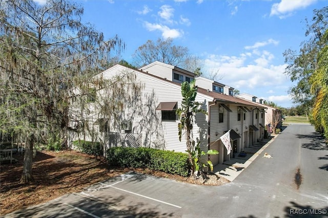 view of property exterior with uncovered parking