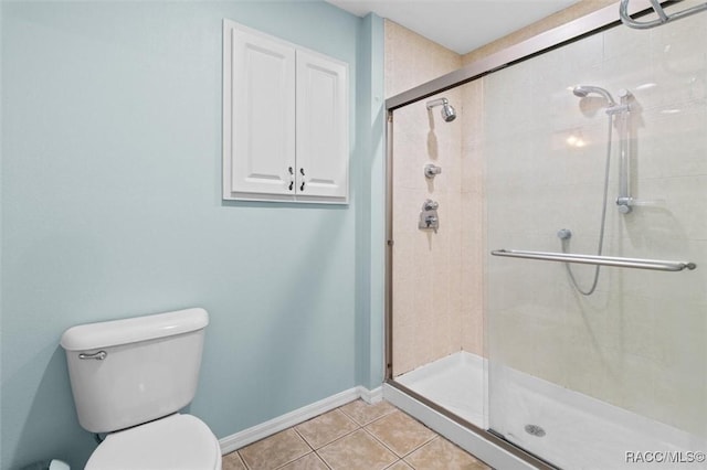 full bathroom featuring baseboards, tile patterned flooring, toilet, and a shower stall