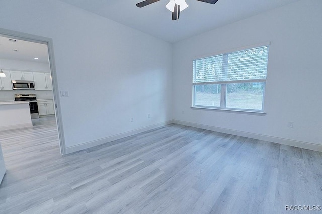 empty room with light hardwood / wood-style floors and ceiling fan