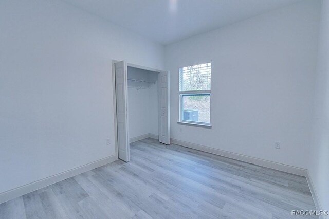 unfurnished bedroom featuring light wood-type flooring and a closet