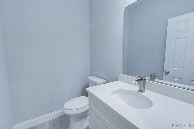 bathroom featuring hardwood / wood-style floors, vanity, and toilet