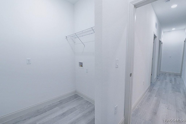 clothes washing area featuring washer hookup and light hardwood / wood-style floors