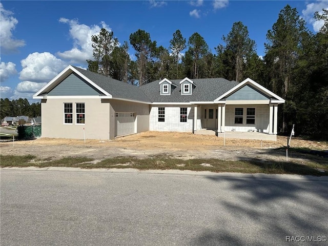 view of front of home featuring a porch and a garage