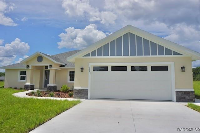 653 E Connecticut Ln, Hernando, FL 34442 - craftsman house with a front yard, driveway, a garage, and stone siding