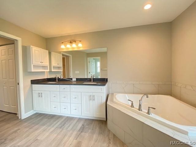 653 E Connecticut Ln, Hernando, FL 34442 - bathroom with double vanity, a bath, and wood finished floors
