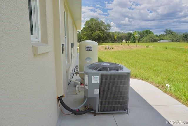 653 E Connecticut Ln, Hernando, FL 34442 - exterior view of stucco siding and a water pressure tank