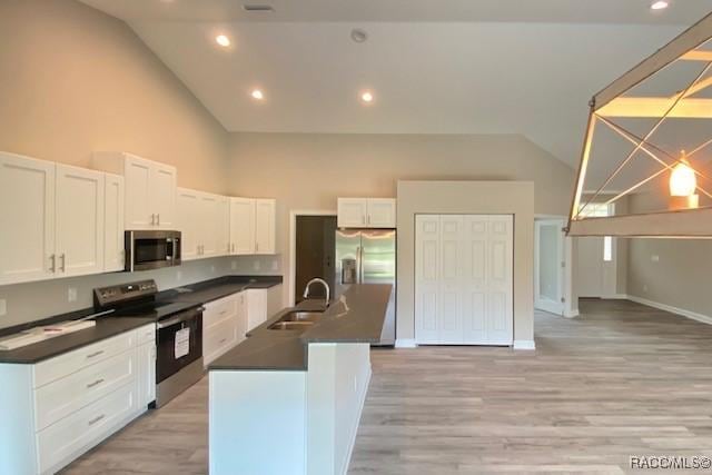653 E Connecticut Ln, Hernando, FL 34442 - kitchen with appliances with stainless steel finishes, dark countertops, high vaulted ceiling, white cabinetry, and light wood-style floors