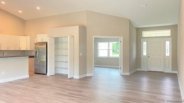 653 E Connecticut Ln, Hernando, FL 34442 - kitchen featuring stainless steel fridge with ice dispenser, open floor plan, light wood-style flooring, white cabinetry, and recessed lighting