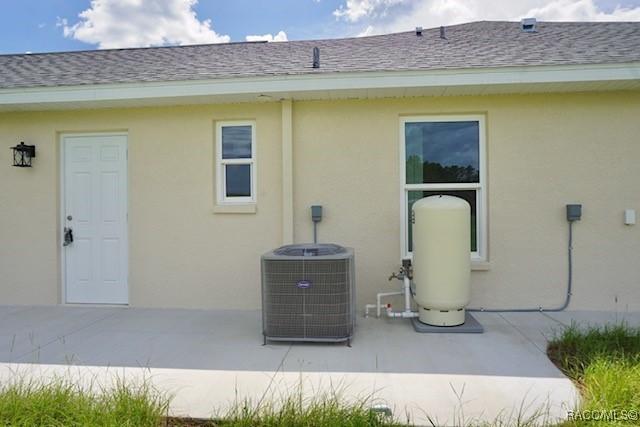 653 E Connecticut Ln, Hernando, FL 34442 - rear view of house with stucco siding, a patio area, and a shingled roof