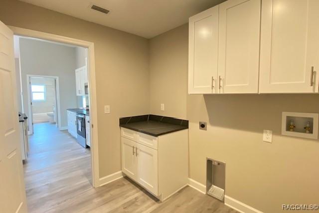 653 E Connecticut Ln, Hernando, FL 34442 - laundry room featuring hookup for an electric dryer, cabinet space, hookup for a washing machine, and light wood-type flooring