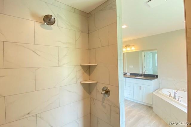 653 E Connecticut Ln, Hernando, FL 34442 - bathroom with a tile shower, a garden tub, and vanity