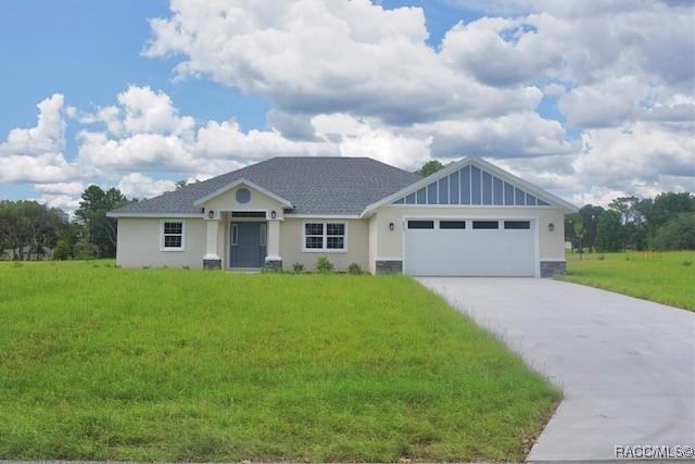 653 E Connecticut Ln, Hernando, FL 34442 - ranch-style house featuring a garage, a front lawn, driveway, and stucco siding