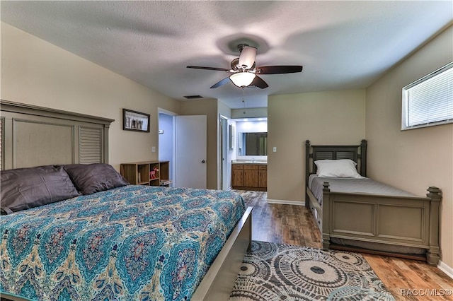 bedroom with ensuite bath, ceiling fan, a textured ceiling, and hardwood / wood-style flooring